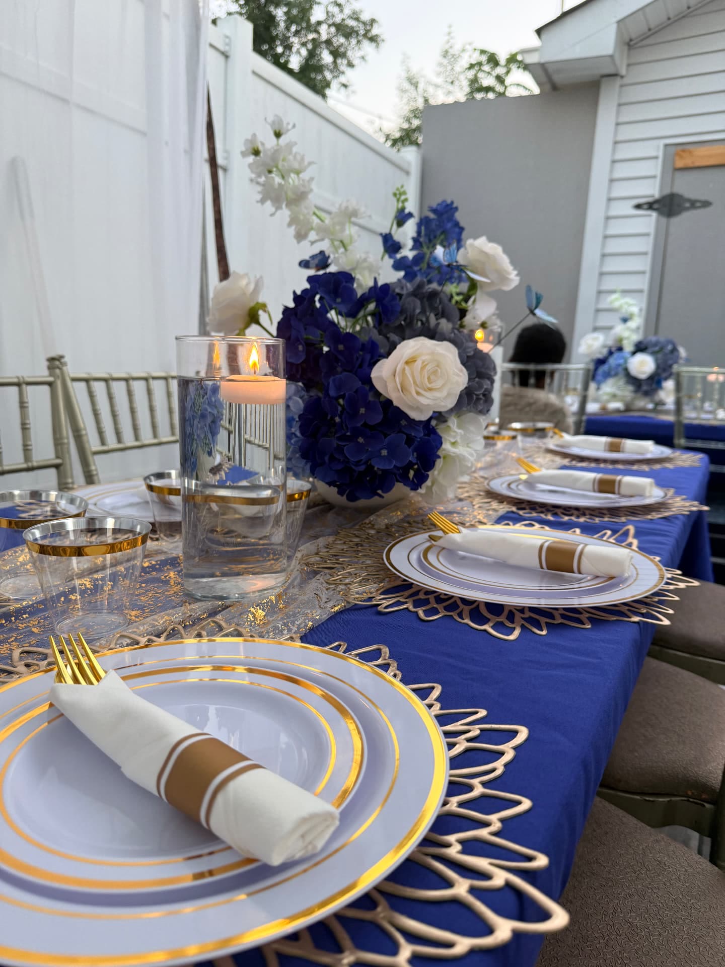 Blue and gold tablescape styled by Raven's Reserve for a 100-plus guest milestone celebration